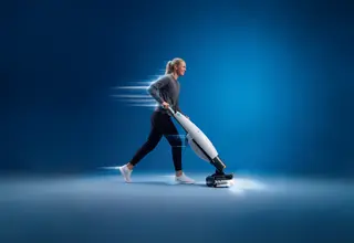 Frau mit blonden Haaren und grauem Pullover schiebt die Scheuersaugmaschine i-mop 46 MODULAR